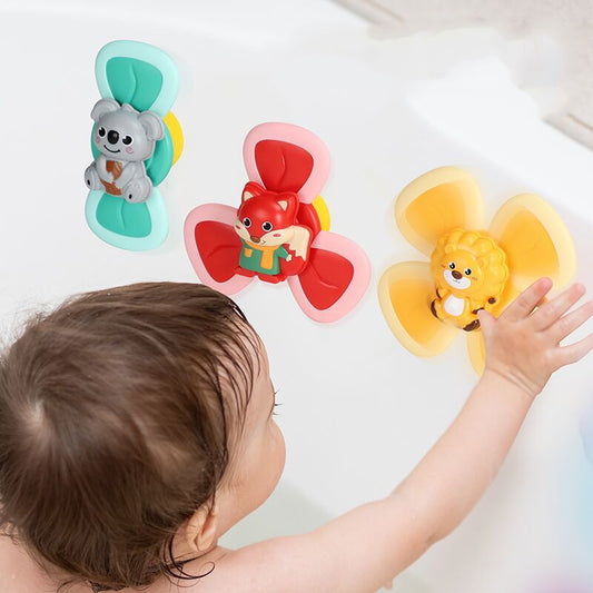 Baby playing with colorful animal-shaped bath toys in a bathtub.