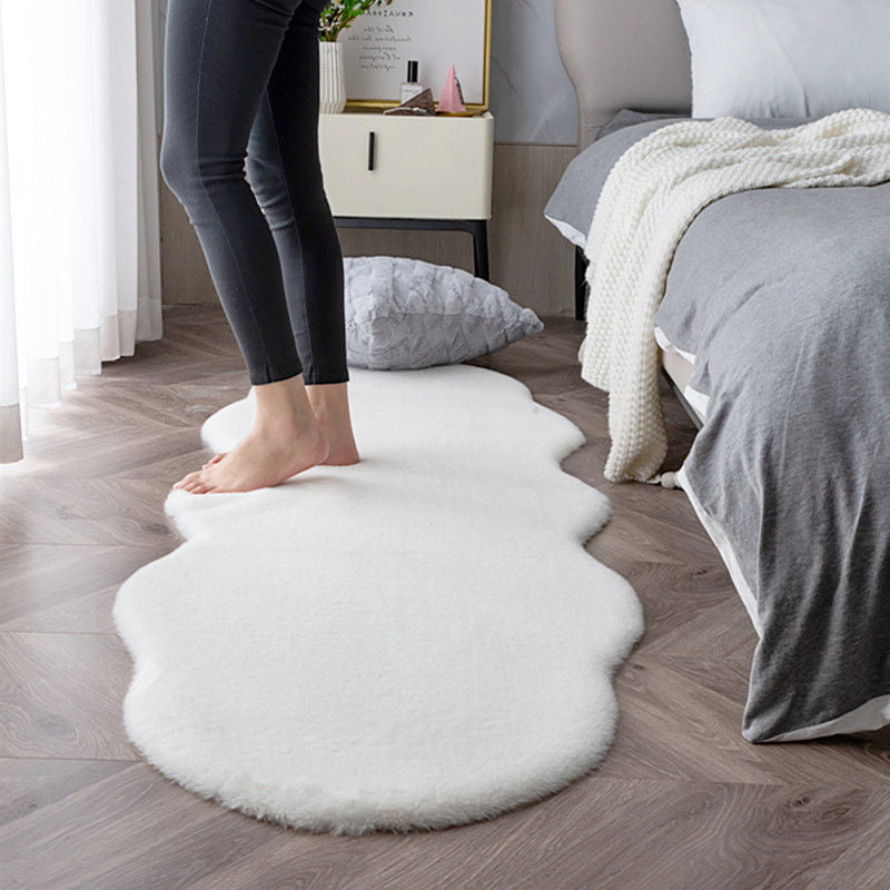 Person standing on a fluffy white rug in a bedroom