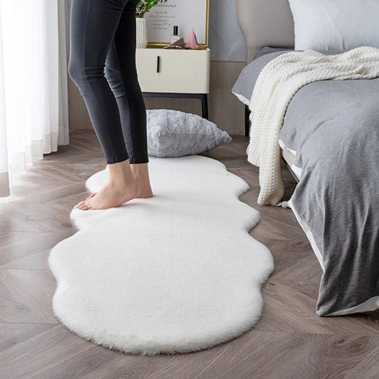 Person standing on a fluffy white rug in a bedroom