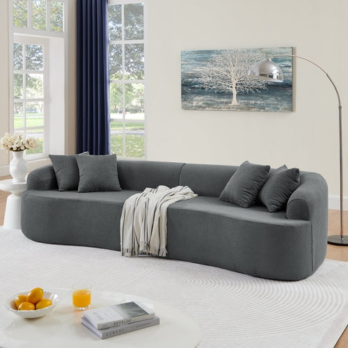 Gray sectional sofa in a living room with a painting on the wall and a coffee table.
