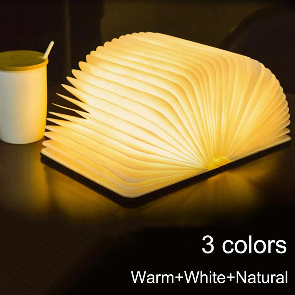 Book-shaped lamp with three color options on a dark surface