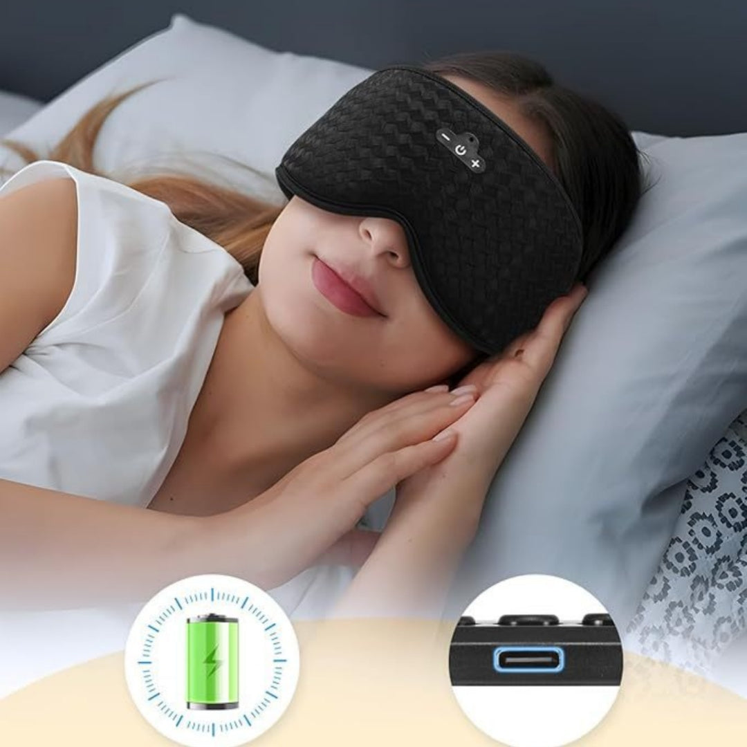 Woman wearing a black sleep mask with charging icons at the bottom.