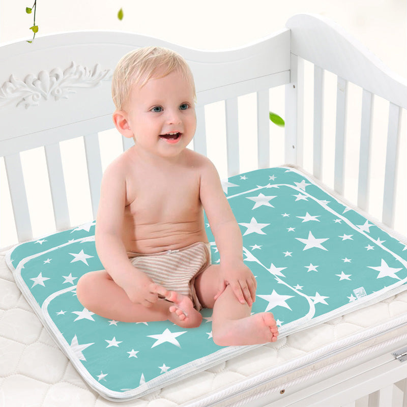 Baby sitting on a star-patterned mat in a crib